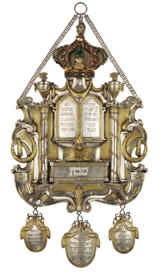 Torah shield, - Inv. No. JMP 046.075 Silver, Prague, 1784, Richard Fleischmann Hammered, chased and cast, partly gilt, set with emeralds and rubies This shield is part of a group of Torah adornments that were commissioned for the Pinkas Synagogue by its warden Wolf Zappert in 1783-1784 On permanent display in the Winter Prayer Hall of the Spanish Synagogue